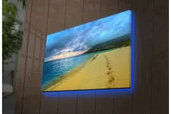 Canvastavla med LED-belysning - Vacker strand med fotspår i sanden och en dramatisk himmel