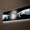 Canvastavla med LED-belysning - Astronauthänder som sträcker sig mot månen