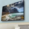 Canvastavla med LED-belysning - Dramatiska berg med snö och en turkos havsstrand