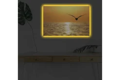 Canvastavla med LED-belysning - Solnedgång över havet med en fågel i flykt