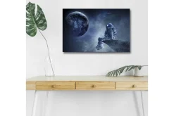 Canvastavla med LED-belysning - Astronaut som sitter på en klippa med jorden i bakgrunden