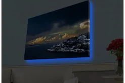 Canvastavla med LED-belysning - Dramatiskt kustlandskap med snöklädda klippor och mörka moln
