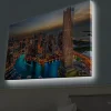 Canvastavla med LED-belysning - Storslagen vy över en modern stad med glittrande skyskrapor och en slingrande flod