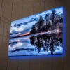 Canvastavla med LED-belysning - Spegelblanka sjölandskap med silhouetter av träd i skymning
