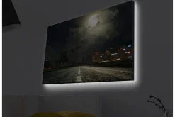 Canvastavla med LED-belysning - Mörk stadssilhuett under en fullmåne med en väg som leder in i fjärran