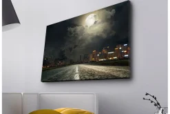Canvastavla med LED-belysning - Mörk stadssilhuett under en fullmåne med en väg som leder in i fjärran