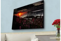 Canvastavla med LED-belysning - Solnedgång över en spegelblanka sjö med blommande växter i förgrunden