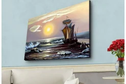 Canvastavla med LED-belysning - Segelbåt på en solig havsstrand med vågor och klippor