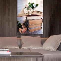 Canvastavla 70x100 cm - Bukett av rosor ligger på en hög av böcker