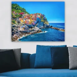 Canvastavla 70x100 cm - Färgglada hus som klättrar uppför en klippa vid havet
