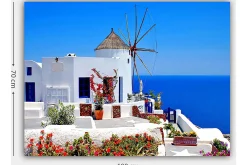 Canvastavla 70x100 cm - Pittoresk vy av en vitkalkad byggnad med en traditionell vindmölla och färgglada blommor i Santorini