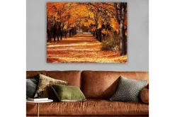 Canvastavla 70x100 cm - Vacker höstscen med träd i starka orangea och gula nyanser som skapar en inbjudande gångväg täckt av fallna löv
